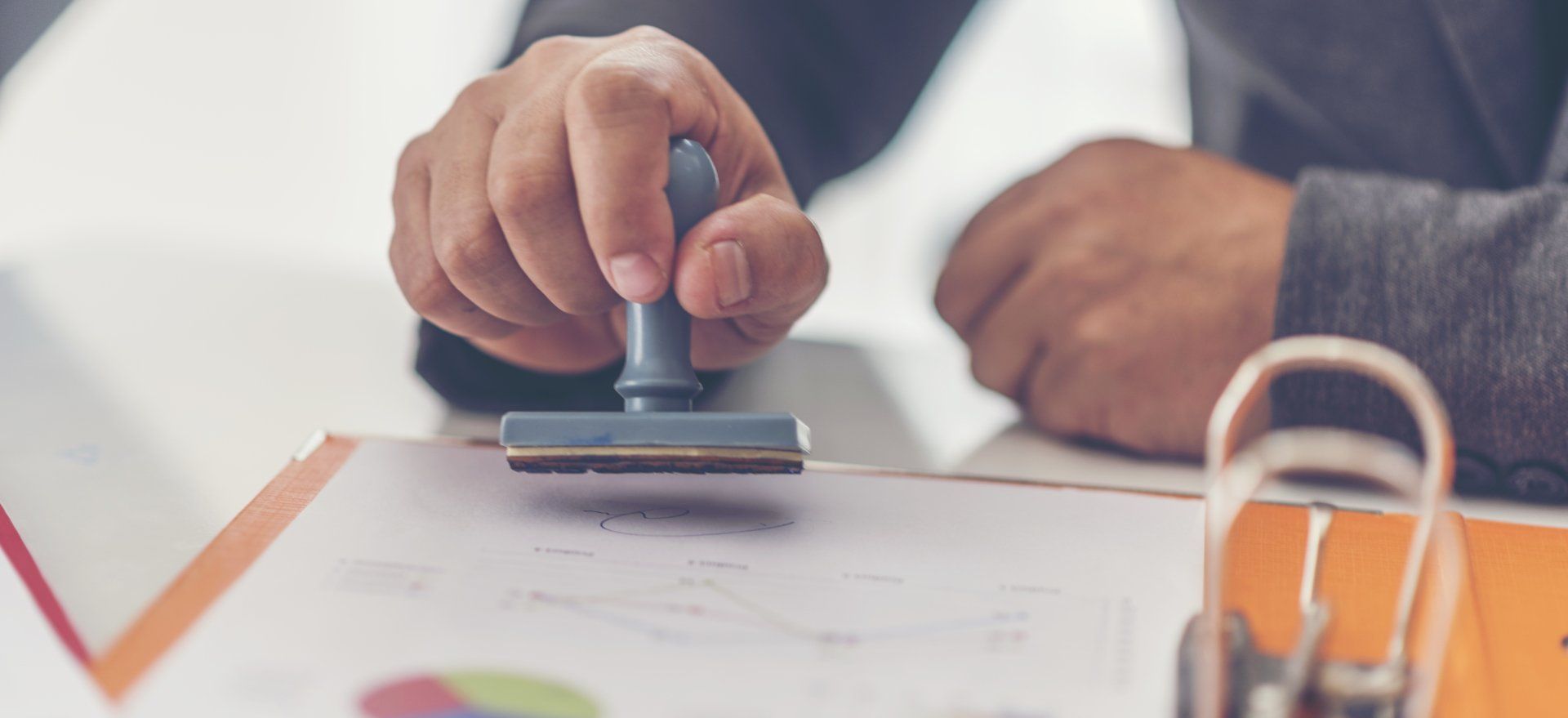 A person is stamping a document on a clipboard.