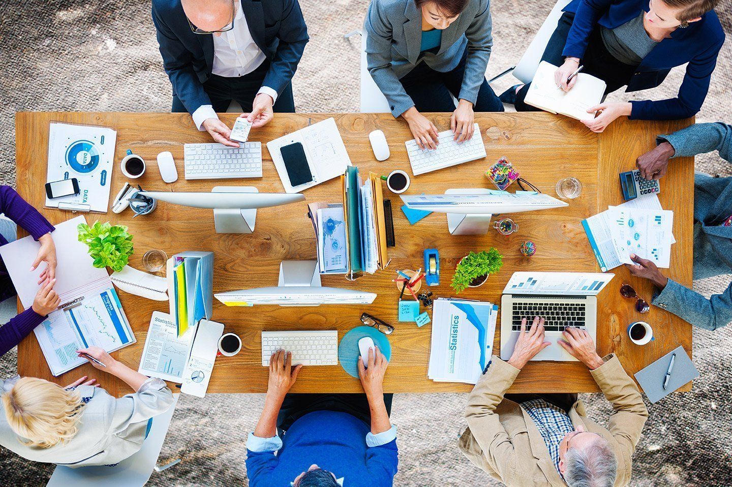 A group of people are sitting around a wooden table.